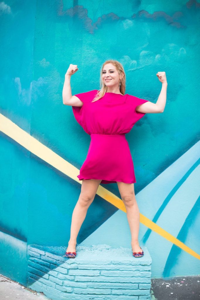 Valentina in front of a mural on a power posture Transforming Negative Emotions into positive ones